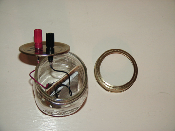 Plates connected by wires to a pair of binding posts, which are mounted in the lid of a Mason jar