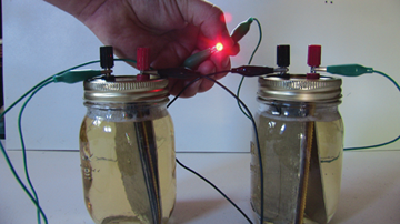 An LED powered from experimental cells through a 500 ohm resistor