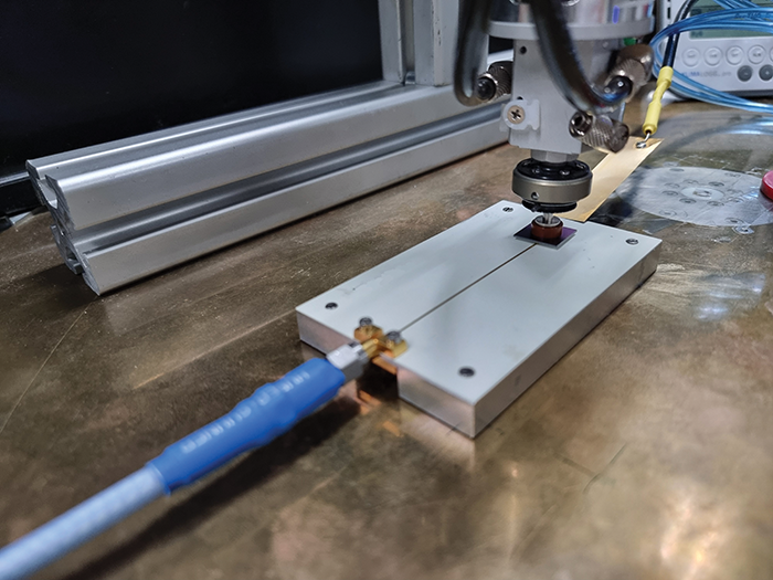 Figure 8: Pick & place measurement setup in laboratory with discharge current sensor (DCS), charging probe, and pick & place head holding a DUT in touchdown position